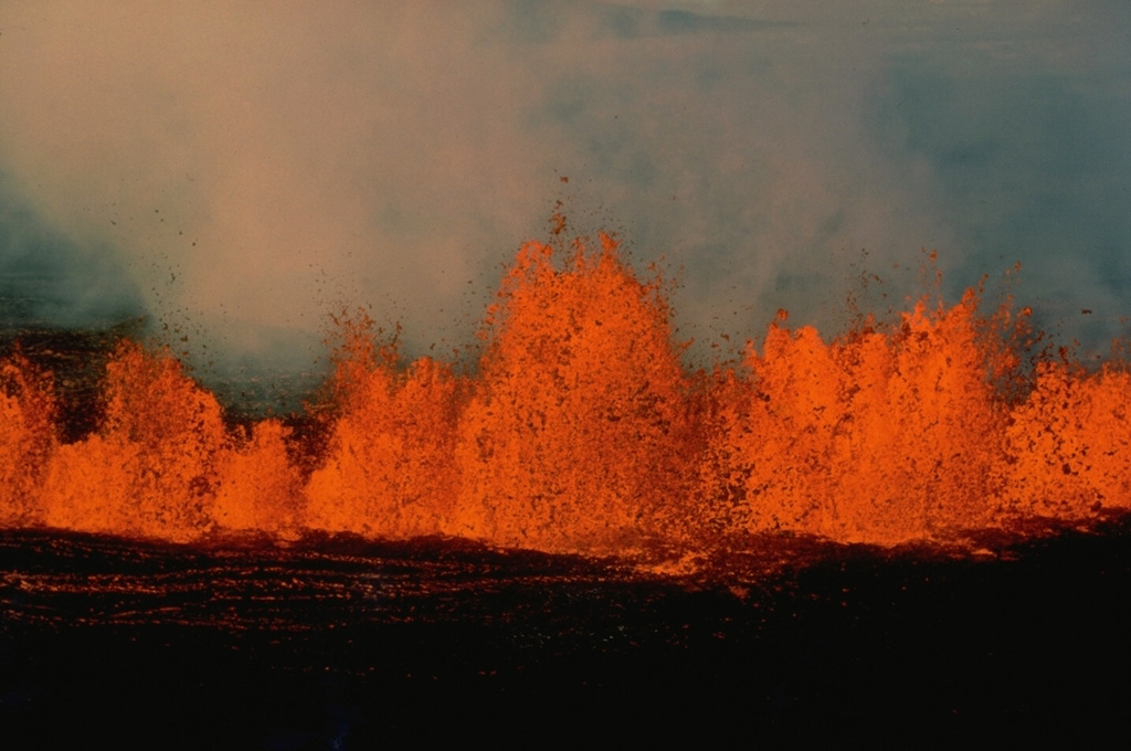 High gas pressure associated with fissure-fed eruptions of basaltic magma produce vigorous lava fountaining that creates a curtain of fire above the eruptive fissure.  These fountains, several tens of meters high, occurred during eruptions along the NE rift zone of Mauna Loa on March 25, 1984. Copyrighted photo by Katia and Maurice Krafft, 1984.