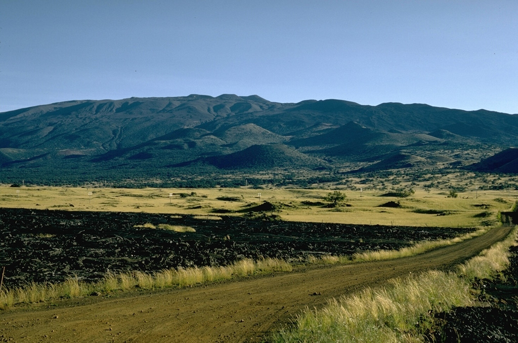 This view of Mauna Kea from the north shows the irregular profile of the summit. The scoria cones in the center of this photo were constructed during eruptions about 4,500 years ago. Photo by Richard Fiske, 1967 (Smithsonian Institution).
