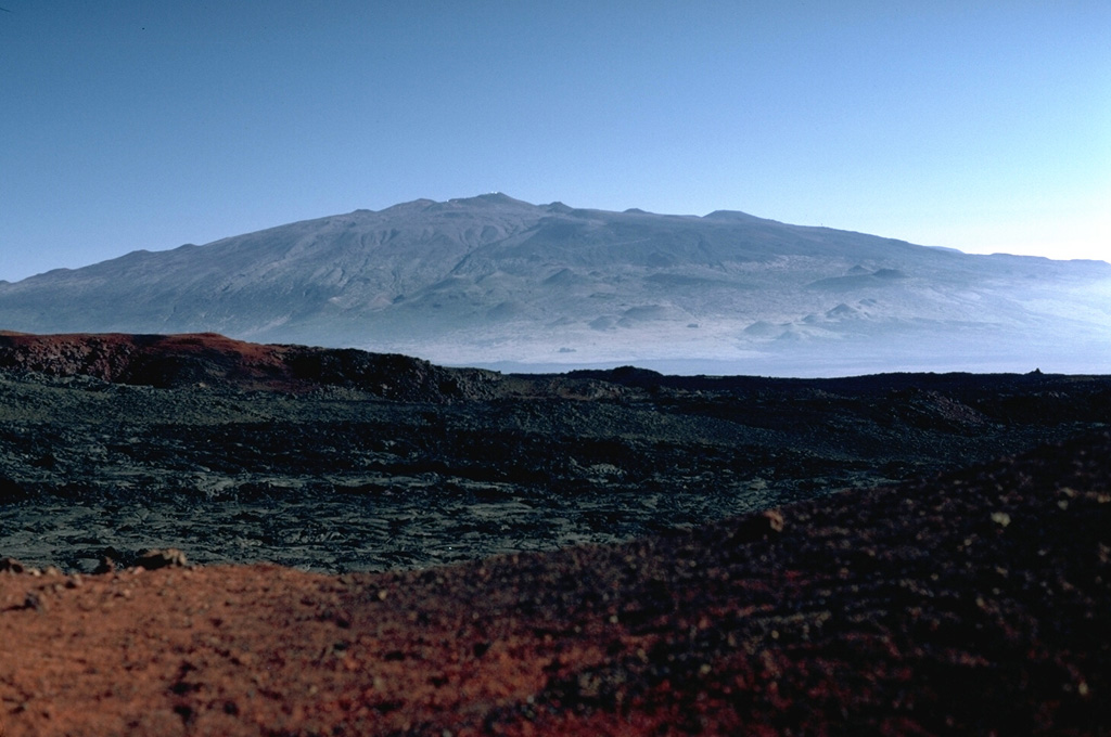 Mauna Kea is seen here from the north along the broad Mauna Loa NE rift zone. The scoria cones that formed during recent eruptions give the volcano an irregular profile. Photo by Lee Siebert, 1987 (Smithsonian Institution).