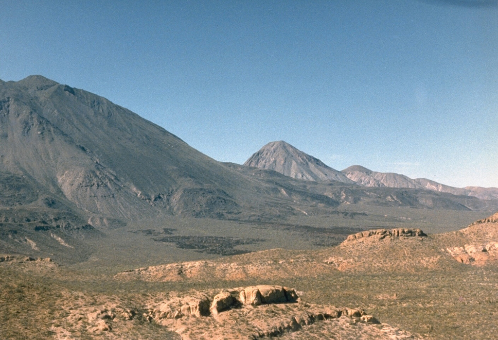 El Azufre volcano (center) is the central peak of the Tres Vírgenes volcanic complex. Its summit lies about 4 km N of the highest peak of the complex, La Vírgen (left). The small peak immediately to the right of El Azufre is El Viejo, the oldest edifice of the complex. El Viejo was constructed SW of the Pleistocene El Aguajito caldera, partly visible on the far-right horizon. Both El Viejo and El Azufre are composed of lava domes and flows. Photo by Marjorie Summers, 1987 (Smithsonian Institution).