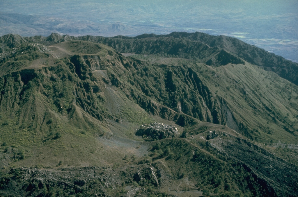 This aerial view of the western part of the summit of Ceboruco shows the rims of the two nested calderas to the upper right. The vent of the 1870-75 eruption contains a small lava dome below center of this photo. A massive lava flow erupted during the 1870 eruption and descended to the lower right.  Photo by Jim Luhr, 1980 (Smithsonian Institution).