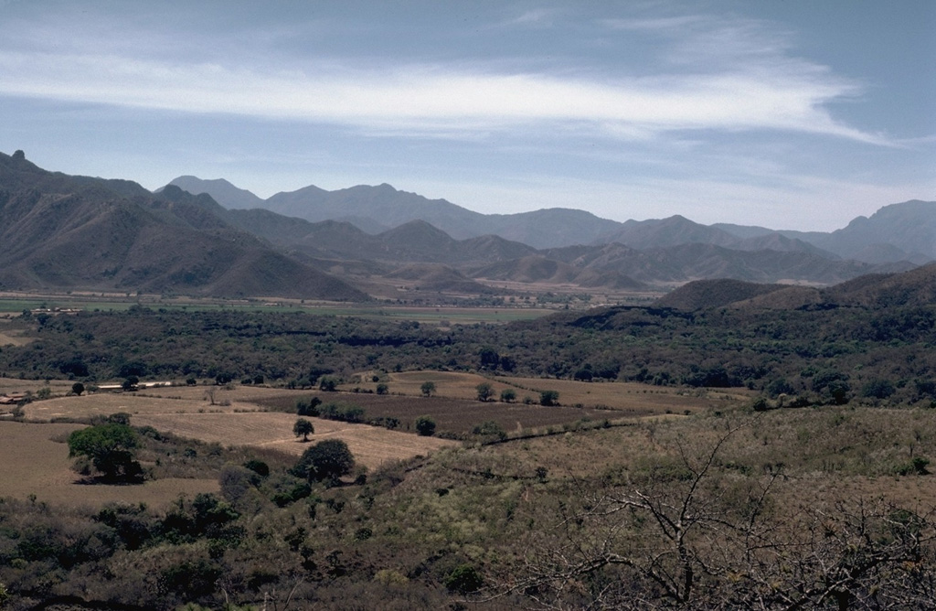 The forested lava flow extending across the valley floor in the center of the photo is from Volcán Malpais in the Mascota Volcanic Field, and may be only a few thousand years old. The flow is seen here looking west across the graben floor from Volcán Molcajete.  Photo by Jim Luhr, 1985 (Smithsonian Institution).