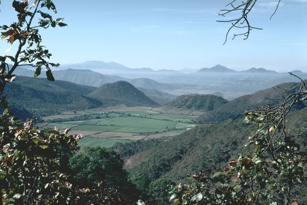 A group of scoria cones and lava domes are located near the town of Mascota, east of Puerto Vallarta. Steep-sided Tecomate lava dome (near the center) and Molcajete scoria cone (right center) are seen here from the NW. A recent eruption produced a lava flow from Volcán Malpais, north of Mascota. Photo by Jim Luhr, 1985 (Smithsonian Institution).