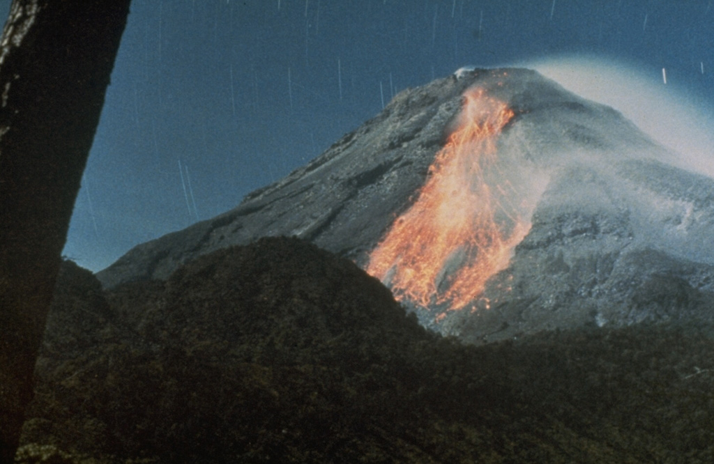 A night-time long exposure photo shows incandescent blocks rolling down the south flank of Colima after being dislodged from the 1982 lava flow. Lava movement down the south flank had begun on 9 December 1981 and was preceded by intermittent small explosions accompanying growth of the summit lava dome. Photo courtesy Julian Flores, 1982 (University of Guadalajara).