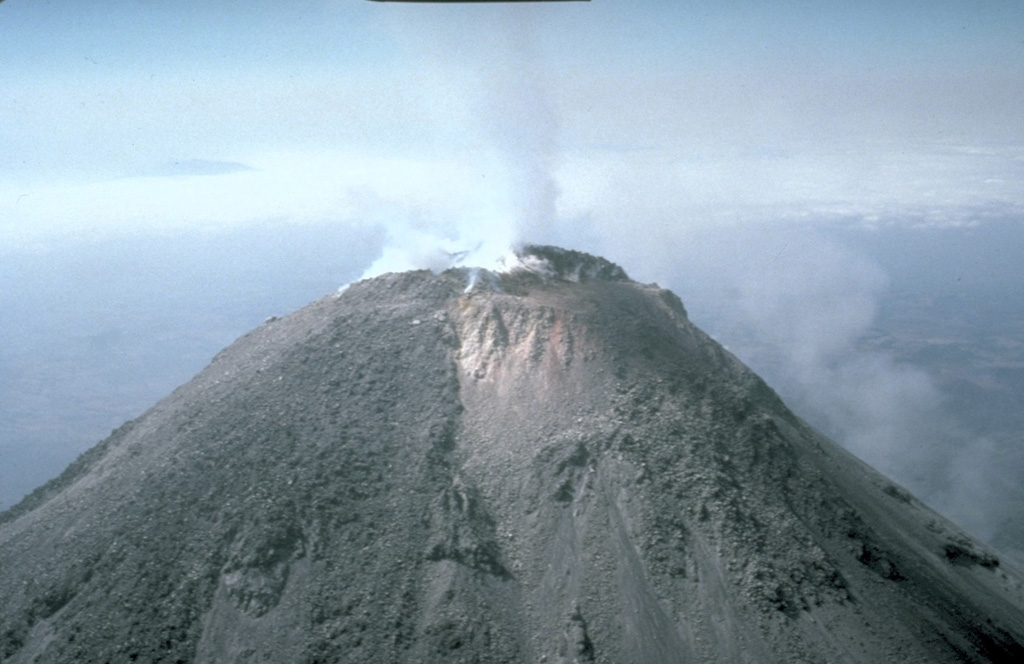 An aerial view from the east shows a weak plume from the 1991 summit dome and the geothermal area directly east of the dome in the 1987 vent. The lighter deposits in center of the photo are hydrothermally altered, forming a highly unstable area similar to those that collapsed to the south on 16 April.   Photo by Claus Siebe, 1991 (Universidad Nacional Autónoma de México).
