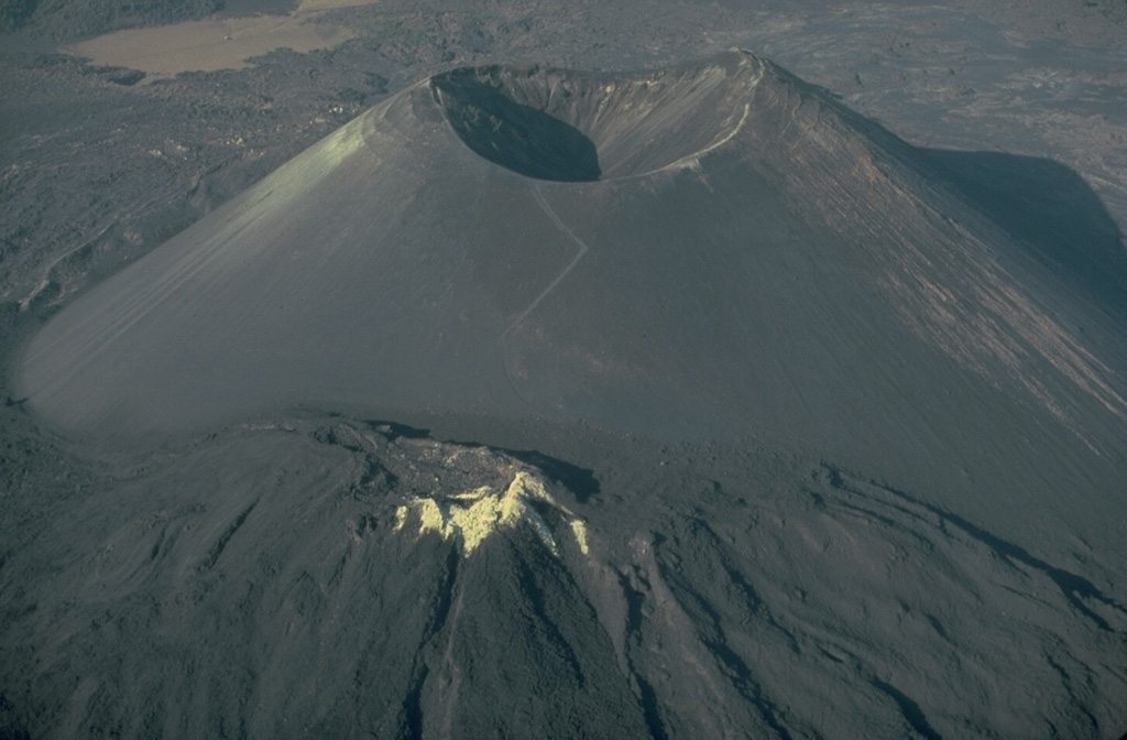 Parícutin cinder cone, born in a Mexican cornfield in 1943, is perhaps the world's best-known example of a pyroclastic cone.  Pyroclastic cones (from the Greek words for "fire" and "broken") are created by the accumulation of explosively ejected fragmental material around a volcanic vent.  Depending on the dominant type of ejecta, they are called cinder cones, scoria cones, pumice cones, ash cones, or tuff cones.  Pyroclastic cones are typically tens of meters to several hundred meters high and often issue lava flows from vents at their base. Copyrighted photo by Katia and Maurice Krafft, 1981.