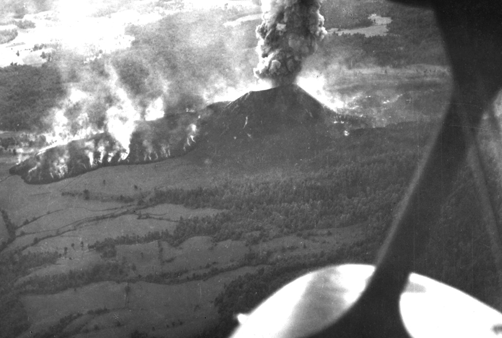 An aerial view from the NNW on 5 March 1943, about two weeks after the start of the Parícutin eruption, shows the Quitzocho lava flow advancing to the NE as an ash plume rises from the scoria cone. The flow was about 6-15 m thick as it advanced.  Photo by Ezequiel Ordonez, 1943 (U.S. National Archives).