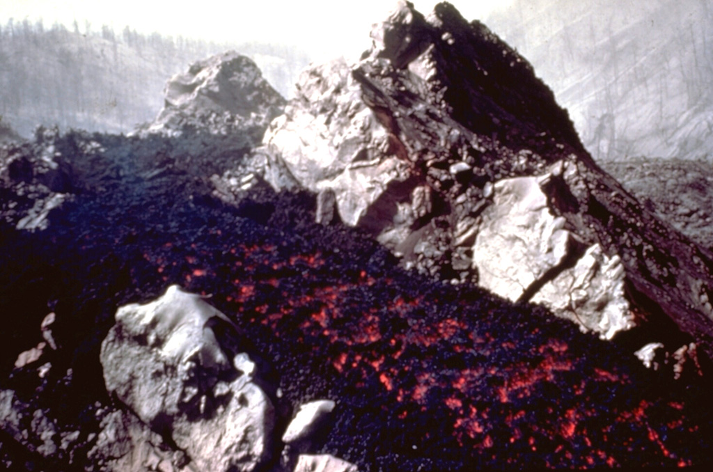 An incandescent lava flow travels down a channel within solidified lava near the SW-flank vents of Parícutin in 1945. Lava flows at this time traveled NW over the site of the village of Parícutin. The Taquí lava flows erupted during 1944-45 and covered about 18 km2. The most striking feature of the Taquí flows was the development of hornitos (rootless vents) when molten lava was ejected through overlying solidified crust. Photo by Ken Segerstrom, 1945 (U.S. Geological Survey, published in Luhr and Simkin, 1993).