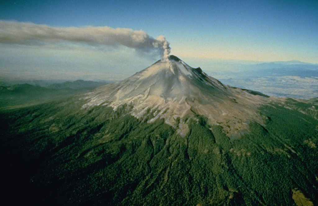 An ash plume rises above Popocatépetl, whose Aztec name means "Smoking Mountain." This aerial view is of the NE side of the massive volcano, which towers more than 3,200 m above the Valley of Mexico to the right in this December 1994 photograph. Frequent eruptions have been recorded since the pre-Columbian era. El Ventorrillo, the small peak on the right, is a remnant of the eroded Nexpayantla volcano, a predecessor to the modern cone of Popocatépetl. Photo courtesy of CENAPRED, Mexico City, 1994.