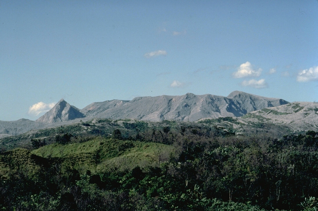 El Chichón is seen in profile from the SSW in January 1983.  The upper flanks of the volcano were completely deforested by the devastating eruptions of March and April 1982.  The sharp peak at the left is the SW lava dome.  The broad ridge at the center is the rim of the 220,000-year-old somma of El Chichón; the 1-km-wide 1982 crater was formed inside the older crater.  Removal of the summit lava dome by the 1982 explosions lowered the height of the summit of El Chichón by about 200 m. Copyrighted photo by Katia and Maurice Krafft, 1983.