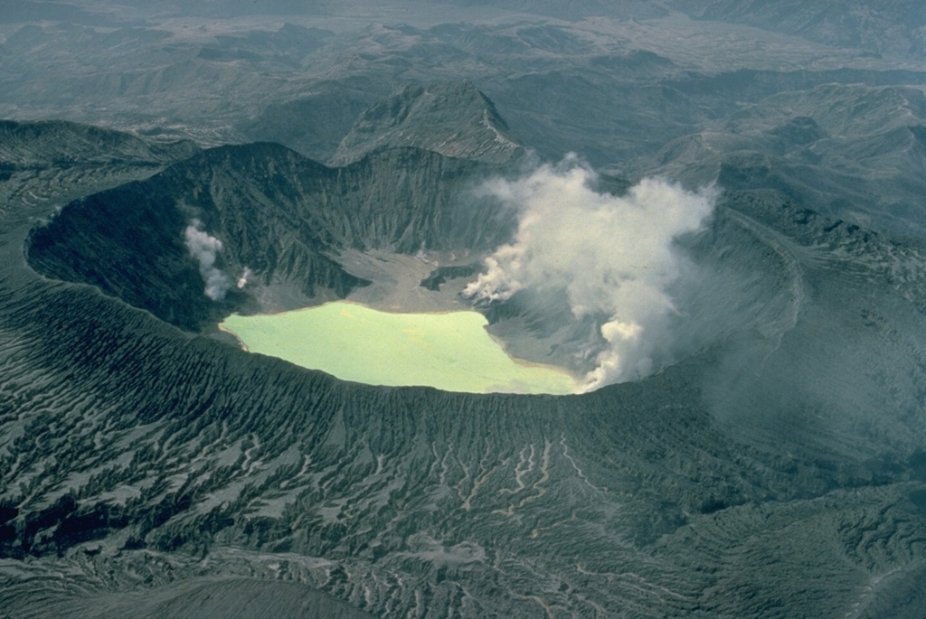 El Chichón is a small, but powerful andesitic stratovolcano that occupies an isolated location in the Chiapas region far from other Holocene volcanoes.  Prior to 1982, this relatively unknown volcano was a heavily forested lava dome cluster of no greater height than adjacent non-volcanic peaks.  This 1983 photo from the NE shows the effects of powerful eruptions in 1982, the first major eruptions at El Chichón in 500 years.  The explosions removed the summit lava dome and created a new 1-km-wide crater now containing an acidic lake. Copyrighted photo by Katia and Maurice Krafft, 1983.