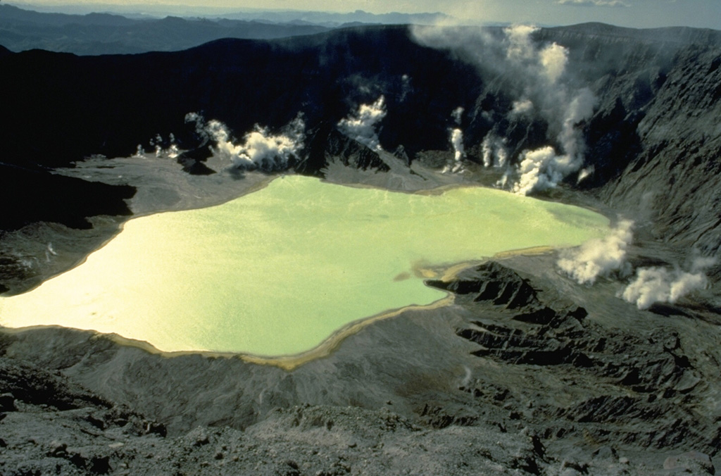 In late April 1982, following a series of powerful explosive eruptions from March 28 to April 4 that created a new 1-km-wide crater at El Chichón volcano, a lake began forming on the crater floor.  By November the lake was up to 600 m wide and about 120 m deep.  Vigorous steam plumes rise from fumaroles below the west crater wall in this March 28, 1983 photo.  In January 1983 the lake was hot (52-58 degrees Centigrade) and acidic (pH of 0.5). Copyrighted photo by Katia and Maurice Krafft, 1983.