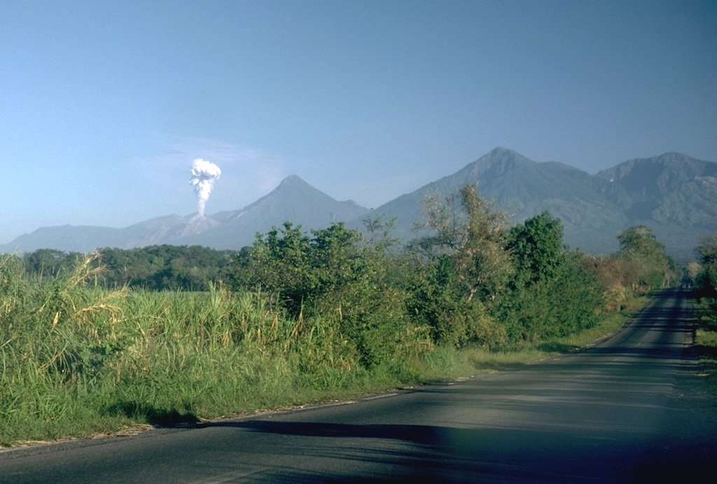 A plume rises from a Santiaguito lava dome on the flank of Santa María. Volcán Santo Tomás is the peak further to the right. A winding ridge connects Santo Tomás to Volcán de Zunil, 4.5 km to the NE, the peak at the far right. Photo by Lee Siebert, 1988 (Smithsonian Institution).