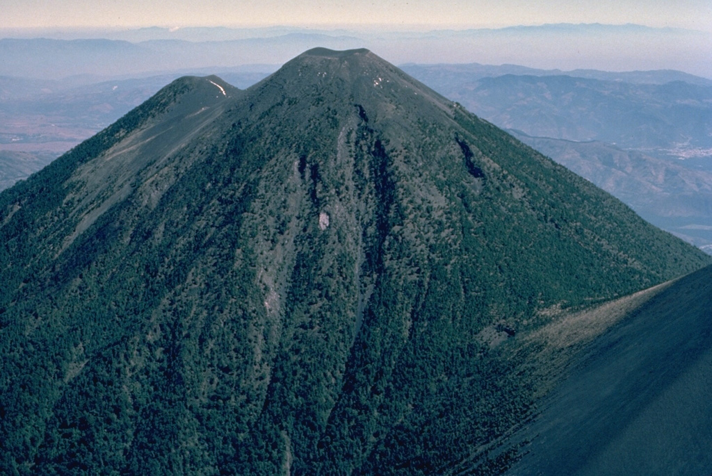 Acatenango, forming a twin volcano with Volcán Fuego to the south, itself has two summits.  Activity at Yepocapa (left), the northern summit of Acatenango, ended about 20,000 years ago, after which the southern and highest cone, Pico Mayor, was constructed.  The first well-documented eruptions of Acatenango took place from 1924 to 1927, although earlier historical eruptions may have occurred.  This aerial view is from the SW. Copyrighted photo by Katia and Maurice Krafft, 1983.