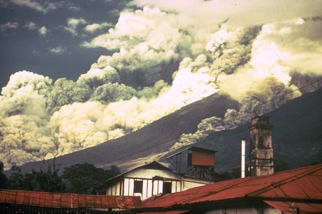 Pyroclastic flows travel down the east flank of Fuego volcano in Guatemala during October 1974 as part of one of the largest historical eruptions of the volcano. Ash plumes rise from the pyroclastic flows, which traveled up to 7 km from the summit at estimated average velocities of 60 km/hour. The denser basal portion of the pyroclastic flow follows topographic lows on the flanks of the volcano. A smaller pyroclastic flow is descending the gully to the right. Photo by William Buell, 1974.