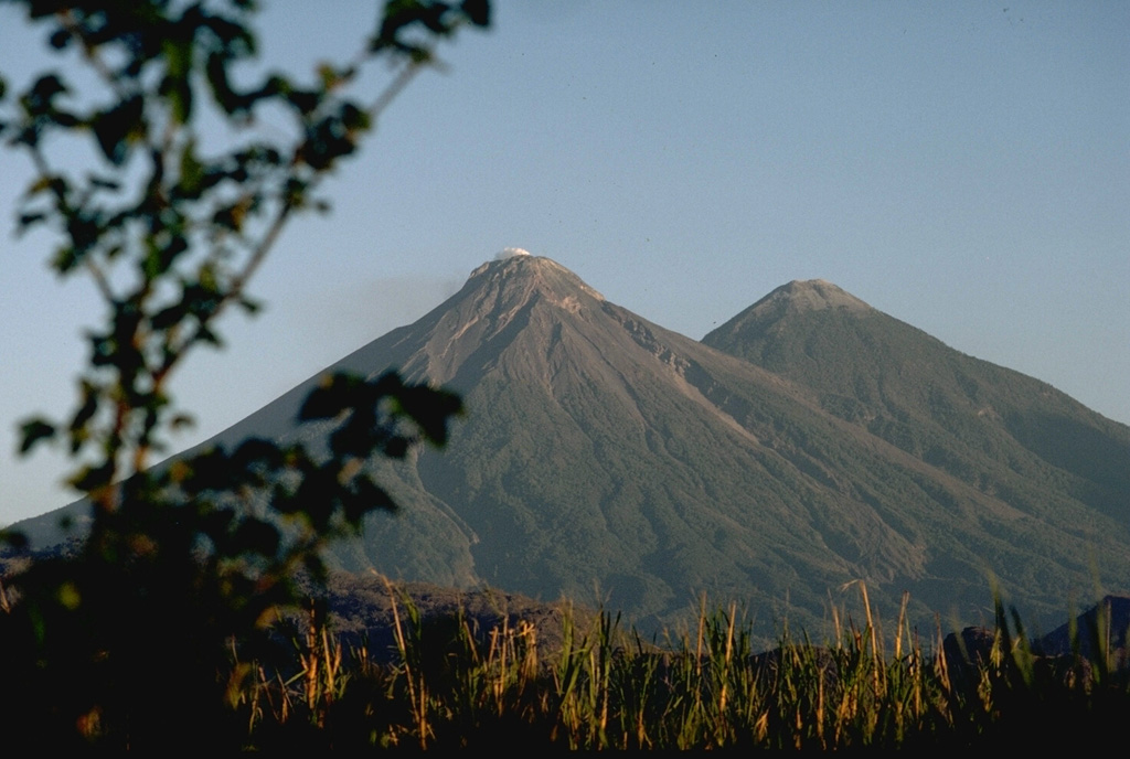 Fuego (left) and Acatenango are two of several paired volcanoes in Guatemala. Activity from the Pleistocene-Holocene Acatenango has continued only sporadically into historical time, but Fuego is one of the most active volcanoes in Guatemala with about 60 historical eruptions. Photo by Lee Siebert, 1988 (Smithsonian Institution).
