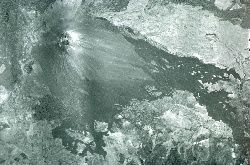 Vegetation-free MacKenney cone was constructed within a large 3 x 6 km crater. The eastern (right) and northern (top) rims are visible in this photo, and formed as a result of massive slope failure of an ancestral Pacaya edifice. Lava flows from MacKenney cone traveled to the west and south beyond the crater. Aerial photograph by Instituto Geográfico Nacional, 1981.