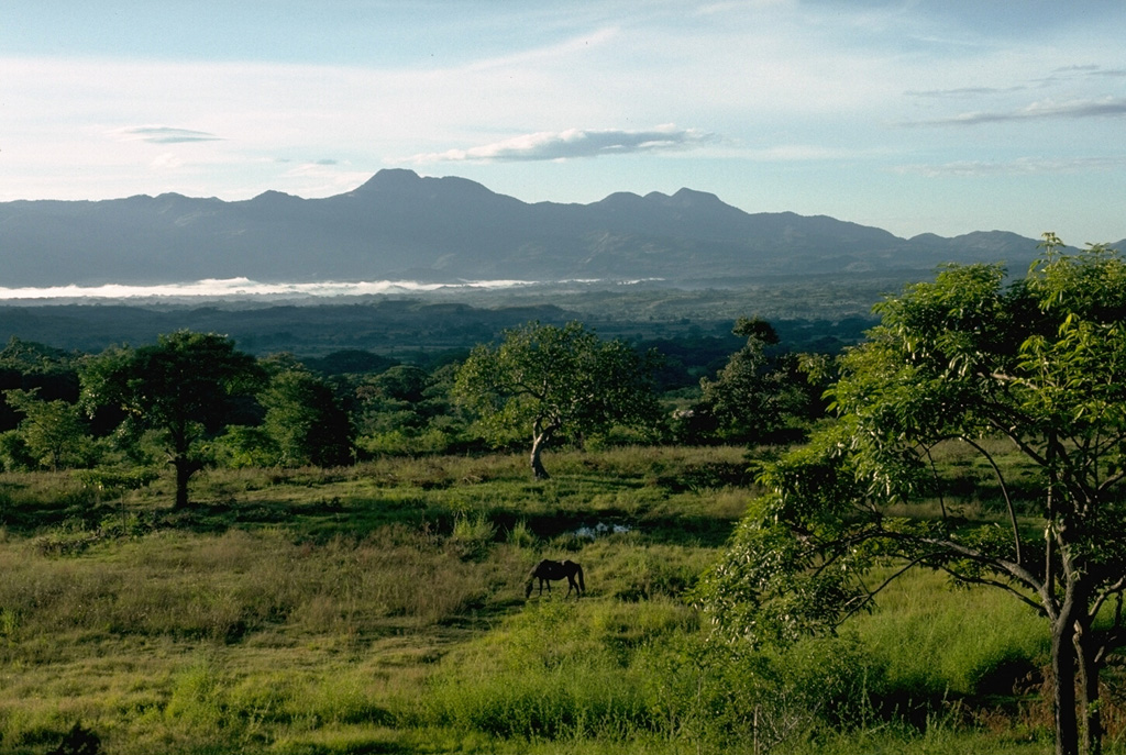 The highest peak in this view is Moyuta and is one of the easternmost of a chain of volcanoes extending across Guatemala. Its flat-topped summit is formed by a cluster of lava domes. The volcano lies south of the NW-SE-trending Jalpatagua Fault and overtops the southern margin of the Jalpatagua Graben. Photo by Lee Siebert, 1988 (Smithsonian Institution).