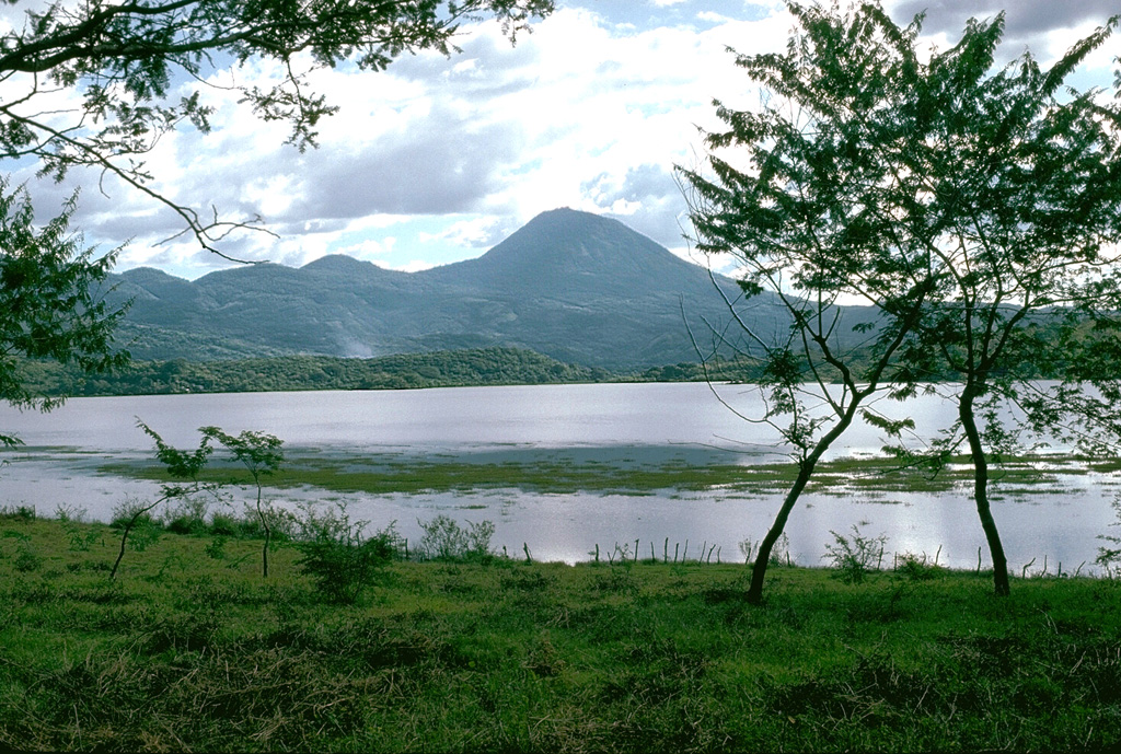 Volcán Chingo, located along the Guatemala/El Salvador border, is the second highest of a group of volcanoes in SE Guatemala. It is seen here from the Guatemalan side above Laguna Atescatempo, which was created when lava flows from the Volcán Chingo area dammed local drainages. Many basaltic scoria cones are located on the flanks on both sides of the border. Photo by Lee Siebert, 1993 (Smithsonian Institution).