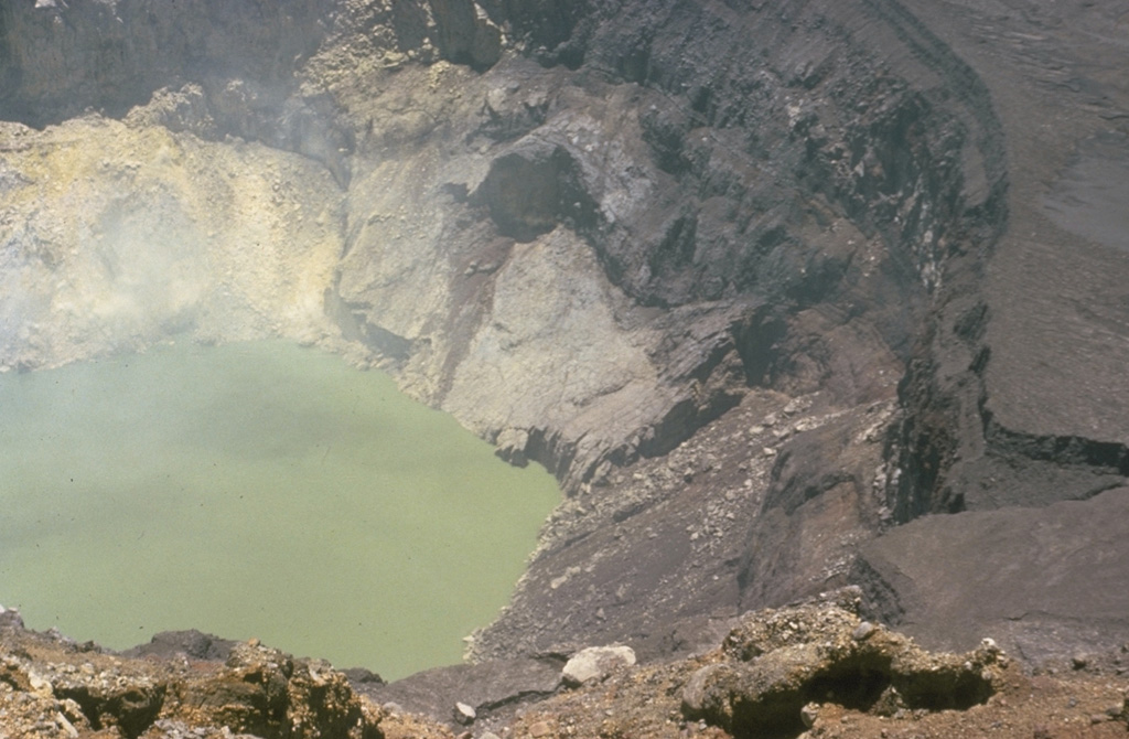 The inner crater of Santa Ana is 500 m wide and is partially filled by a 250-m-wide greenish crater lake in this 1966 photo. Fumaroles are active on the crater wall and in the lake, and abundant sulfur deposits are located on the SW wall (upper left). The acidic crater lake has a pH of about 1, and bathymetric surveys have revealed a maximum depth of 27 m. Photo by Dick Stoiber, 1966 (Dartmouth College).