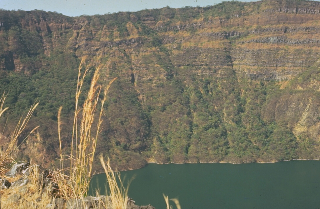 The steep-sided caldera walls of Cosigüina volcano rise 500 m above a lake on the caldera floor.  Inter-bedded gray lava flows and brownish pyroclastic deposits forming the pre-caldera stratovolcano are exposed in the far wall.  Observers of Cosigüina prior to the catastrophic 1835 eruption described the volcano as being of low height, with a flat top, suggesting that the caldera was in existence prior to the eruption. Photo by Jaime Incer.