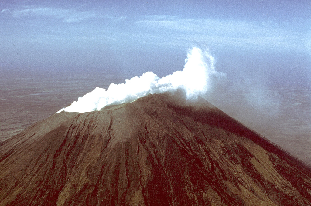 A vigorous white steam plume, seen here from the NW, rises from the summit crater of San Cristóbal volcano in March 1976.  Small ash eruptions occurred from San Cristóbal on March 9-10, 1976, dropping ash on the town of Chinandega, 10 km to the SW.  Ashfall from another eruption on March 16 was restricted to the summit crater area.  Collapse of cones within the summit crater during this eruption created a new 300-m-wide vent. Photo by Dick Stoiber, 1976 (Dartmouth College).
