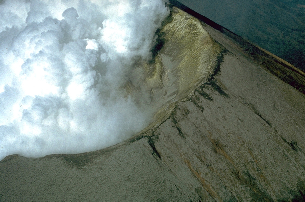 Steam clouds fill much of the crater of San Cristóbal volcano in March 1976.  After a quiescence of about five years, small ash eruptions took place at San Cristóbal on March 9-10, 1976, dropping ash on the nearby town of Chinandega.  During an eruption on March 16 ash was confined primarily to the summit crater area.  The summit crater of San Cristóbal is 500-600 m wide. Photo by Dick Stoiber, 1976 (Dartmouth College).