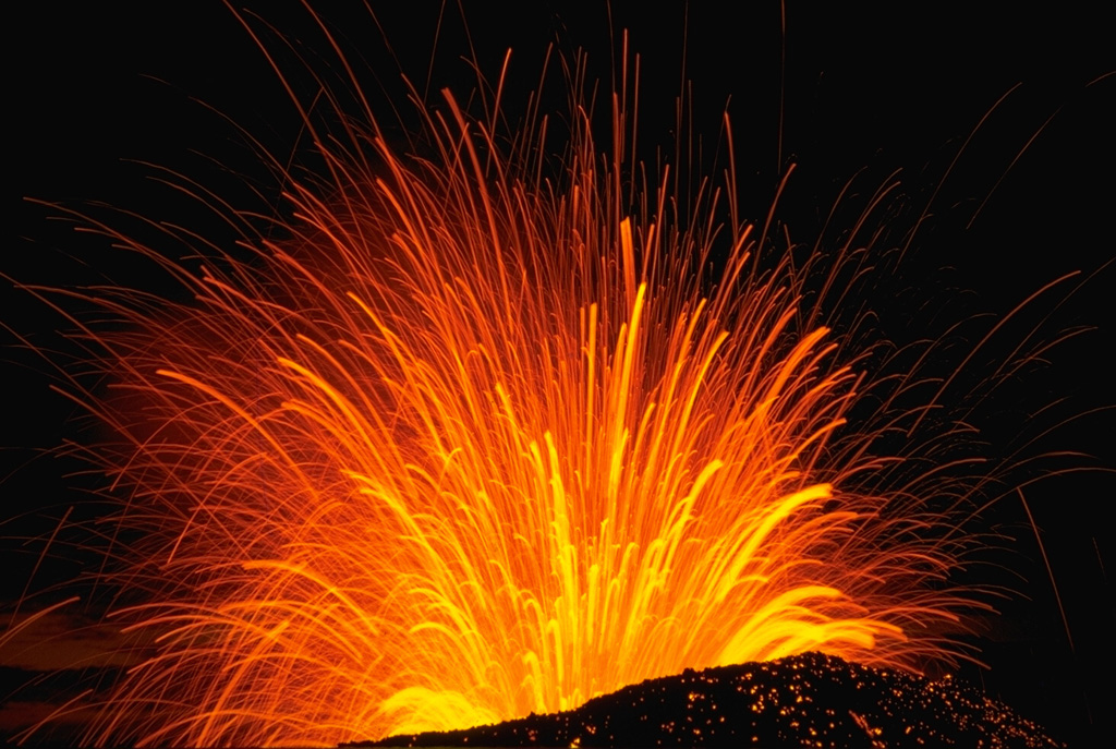 A long-exposure nighttime view of a Strombolian explosion at Cerro Negro volcano in Nicaragua in November 1968. The trajectory of individual incandescent volcanic bombs can be seen radiating from the vent. Hot, incandescent bombs are visible on the outer flanks of the scoria cone.  Photo by Robert Citron, 1968 (Smithsonian Institution).