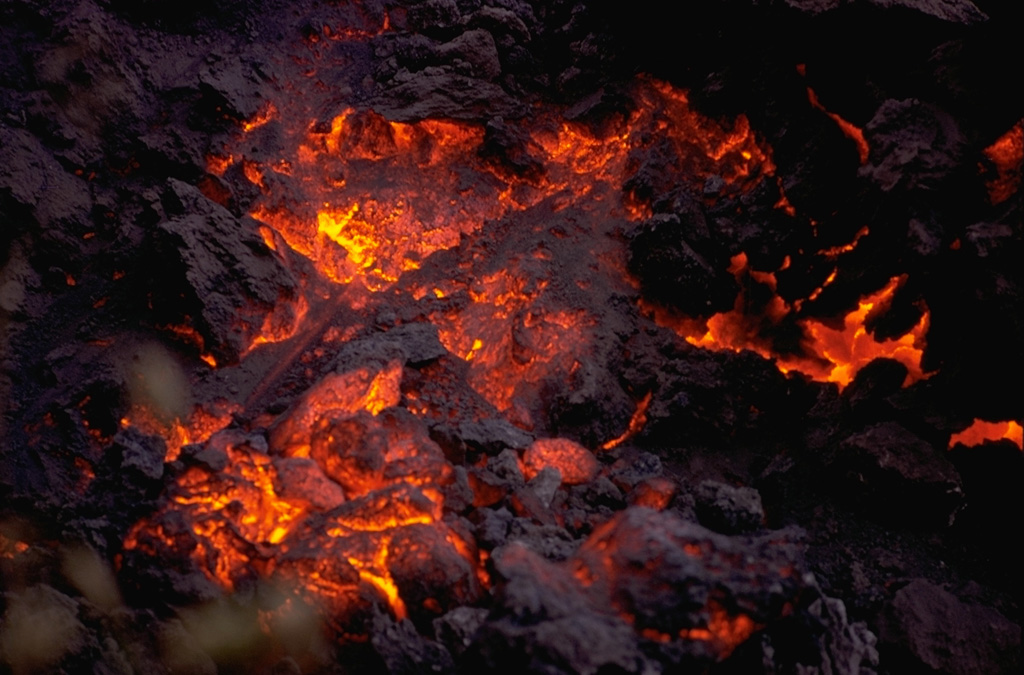 Incandescent lava is visible on the cooling surface of an advancing lava flow from Cerro Negro volcano in 1968.  The flow front, which advanced at a rate of about 5 m/hr during the first day of the eruption.  The flow originated from a horseshoe-shaped flank vent south of Cerro Negro. Photo by William Melson, 1968 (Smithsonian Institution).