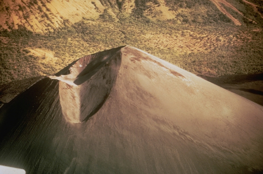 This December 1969 photo shows the crater of Cerro Negro a year after the end of  the 1968 eruption.  The two craters, separated by a narrow septum, are located north of the summit of the cone.  The slopes of Las Pilas volcano are in the background.  The morphologies of Cerro Negro's crater and summit have varied dramatically during the course of historical eruptions as a function of the location of the eruptive conduits, vigor of the eruptions, and direction of prevailing winds. Photo by Willard Parsons, 1969 (courtesy of Bill Rose, Michigan Technological University).