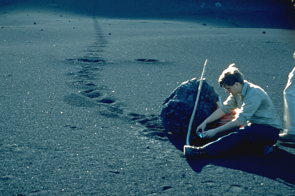 Volcanologist Bill Rose measures a large bomb ejected during the 1971 eruption of Cerro Negro volcano.  The bomb landed on the flank of the cinder cone and rolled across the surface of fresh ash.  The 1971 eruption took place February 3-14.  Heavy ashfall produced extensive crop damage.  This photo was taken in March 1971. Photo by Dick Stoiber, 1971 (Dartmouth College).