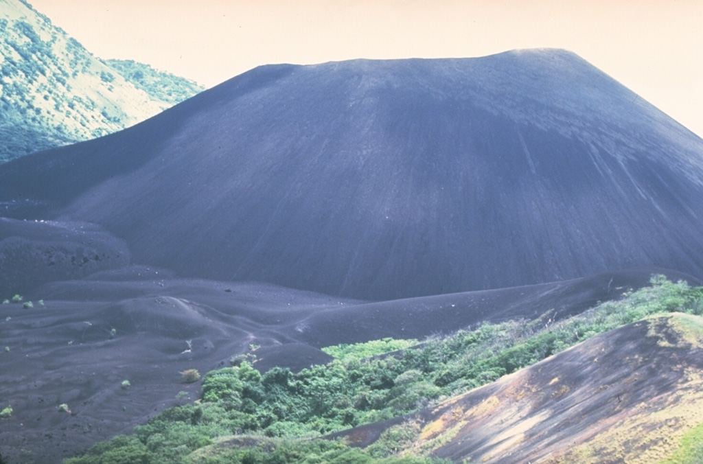 The Cerro Negro scoria cone formed in April 1850. It has been one of Nicaragua's most active volcanoes, building up a roughly 250-m-high cone surrounded by a field of young lava flows. Cerro Negro is seen here in 1981 from Cerro la Mula to the north, the next in a chain of four cinder cones erupted along a N-S line. Photo by Mike Carr, 1981 (Rutgers University).