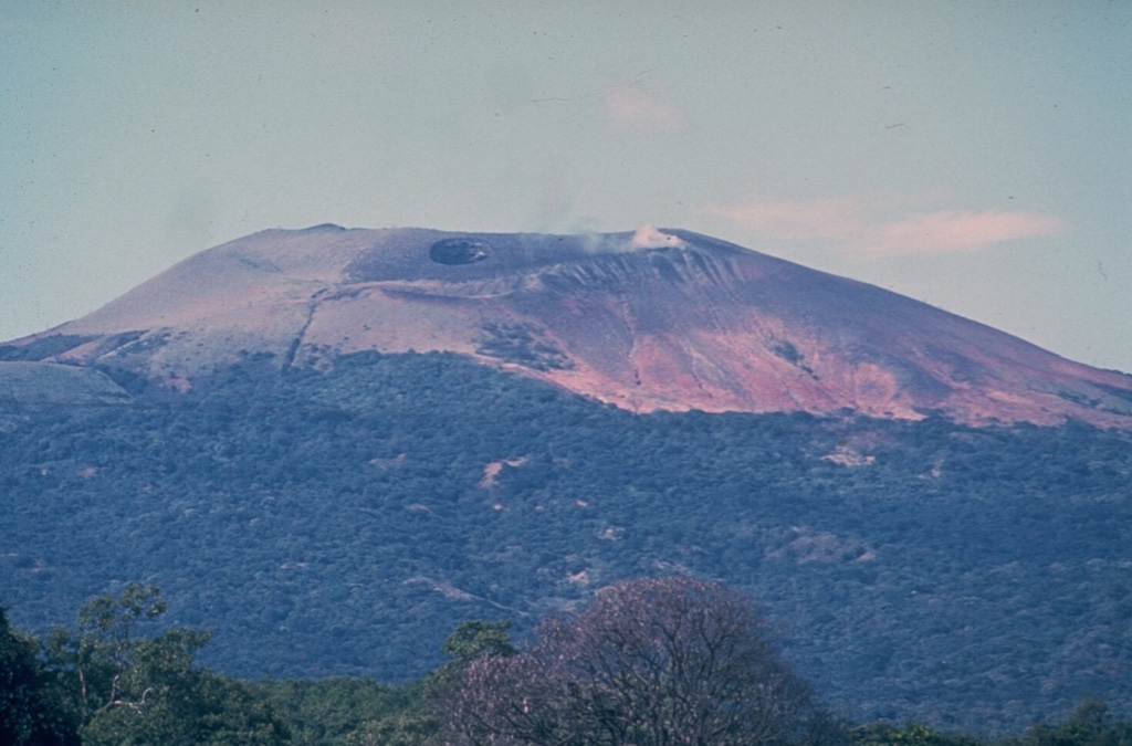 The southern side of Las Pilas volcano is cut by a prominent transverse fissure, seen steaming in this 1970 view from the SW.  A small circular pit crater, El Oyo, is located above the fissure just below the crater rim.  Aside from a possible eruption in the 16th century, the only historical eruptions of Las Pilas took place in the 1950s from a fissure that extended across the east side of the 700-m-wide summit crater and down the north flank.        Photo by Dick Stoiber, 1970 (Dartmouth College).
