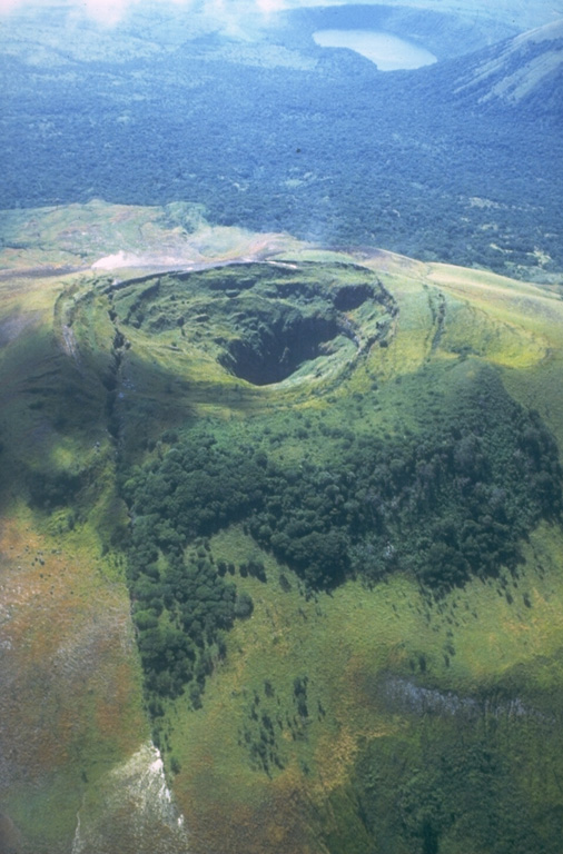 The 1-km-long fissure that reaches from the lower left across the summit crater of Las Pilas was formed during an eruption in 1952.  The eruption, which began on October 23, produced ash-bearing steam clouds that ejected fragments of rock from the walls of the new fissure.  The eruption ended in December.  This view from the north shows the undated Laguna de Asososca maar (upper right), which was formed near the southern end of the fissure system cutting across Las Pilas volcanic complex. Photo by Jaime Incer, 1981.
