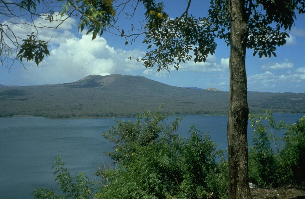 Masaya is one of Nicaragua's most unusual and most active volcanoes.  It is a broad, 6 x 11 km basaltic caldera with steep-sided walls up to 300-m high.  The caldera is filled on its NW end by more than a dozen vents erupted along a circular, 4-km-diameter fracture system.  The twin volcanoes of Nindirí and Masaya are seen here from the east caldera rim above Lake Masaya.  Masaya has been frequently active since the time of the Spanish Conquistadors, when an active lava lake prompted several attempts to extract the volcano's molten "gold."     Photo by Jaime Incer.