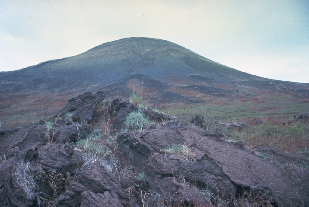 A tumulus on the surface of a pahoehoe lava flow in the foreground is exposed on the western flank of Masaya volcano, with Nindirí cone rising in the background.  Nindirí is the westernmost cone of Masaya's summit complex and is cut by a large summit crater not apparent from this vantage point.   Photo by Jaime Incer.