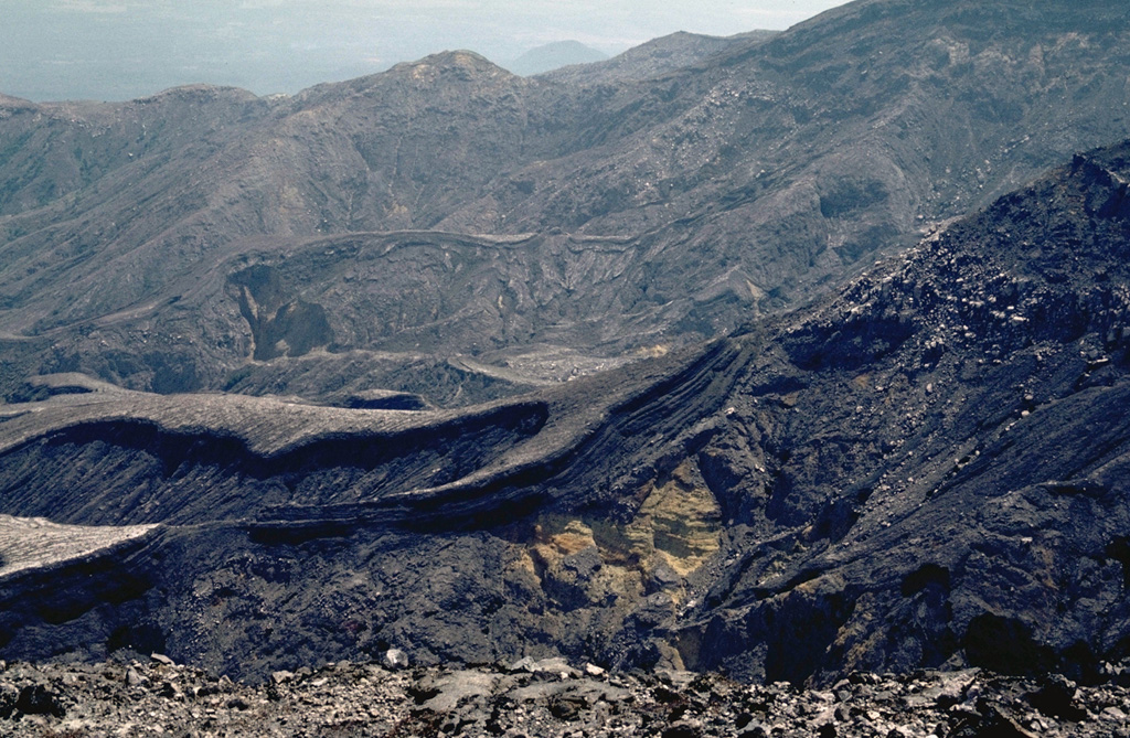 The Rincón de la Vieja SW flank contains a broad area almost entirely devoid of vegetation resulting from eruptions and acid rain. Steady trade winds from the NNE distribute acidic gases from Cráter Activo to the SW.  Photo by William Melson, 1986 (Smithsonian Institution).