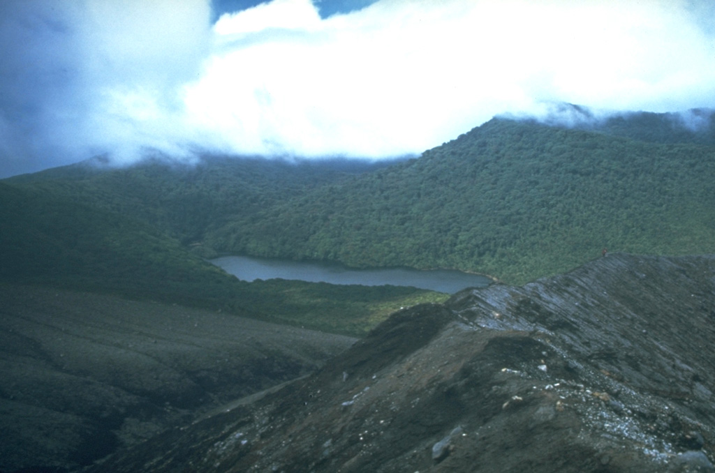 Laguna de Fria (center) is seen here from the west, along a ridge near Cráter Activo. It formed when meteoric water accumulated in a depression between overlapping cones of the Rincón de la Vieja complex. Rincón de la Vieja cone is to the upper right.  Photo by Cindy Stine, 1989 (U.S. Geological Survey).