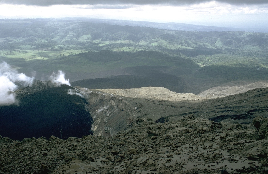 A lava flow issuing from Crater A is seen in April 1969. This crater was the source of the largest explosions at the onset of the eruption in July 1968. The distal end of the lava flow can be seen across the center of the photo. This flow initially traveled down the Río Tabacón on the NW flank, but later sent lobes over a broad area extending to the SW. Photo by William Melson, 1969 (Smithsonian Institution).