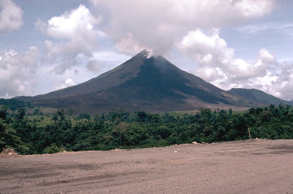 Arenal is seen here from the west in May 1981, with lava flowing from Crater C near the summit. The eruption began in July 1968 with powerful explosions from three craters on the west flank, with the strongest explosions from Crater A. In subsequent years activity migrated towards the summit and took place primarily from Crater C as well as from Crater D (near the former summit). Photo by William Melson, 1981 (Smithsonian Institution).
