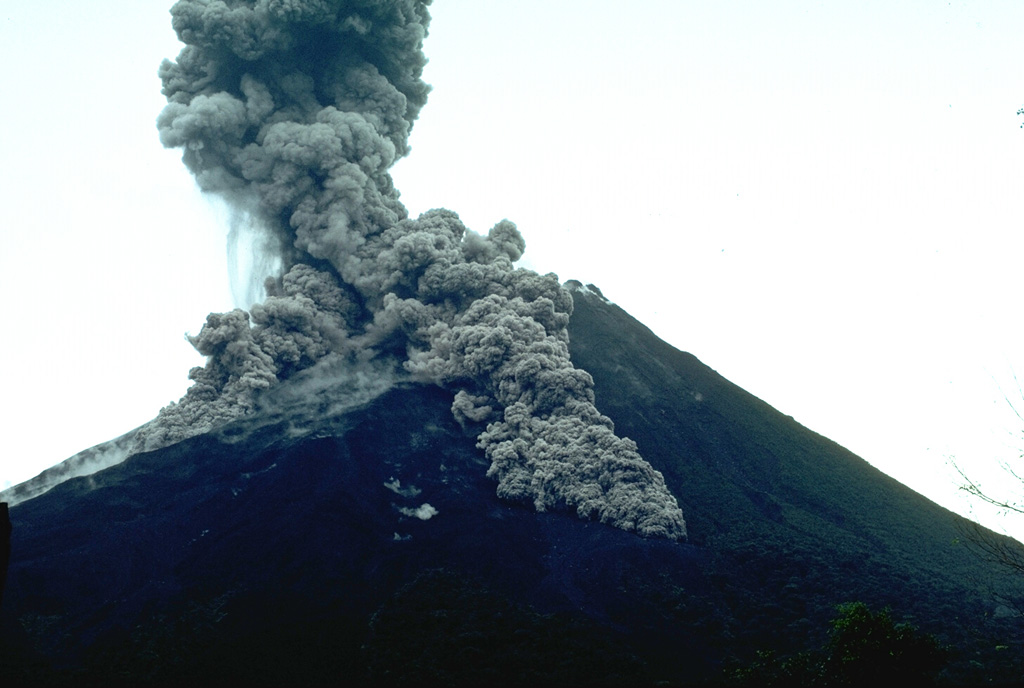 Pyroclastic flows descend the flanks of Arenal on 7 July 1987. This was part of the long eruption that began in 1968. The largest pyroclastic flow in this photo taken from the volcano observatory (2.5 km SSW of the summit) is traveling down the SSE flank. Photo by William Melson, 1987 (Smithsonian Institution)