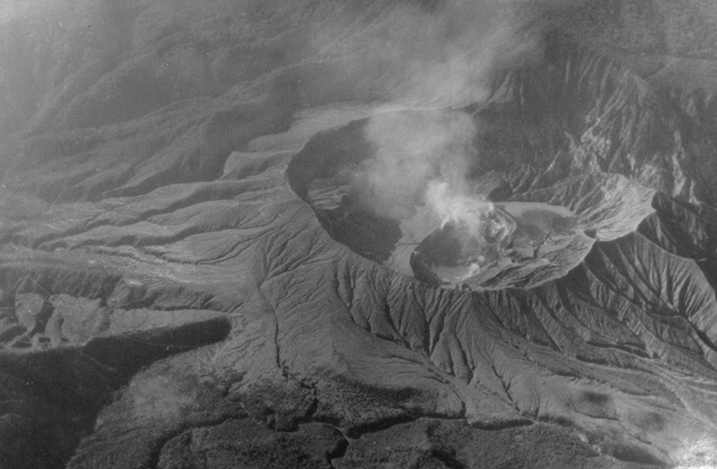 This June 1956 shows gas emissions from a new circular sub-crater formed in the summit crater of Poás volcano during an eruption from 1952-57. Phreatic explosions increased in intensity from 1952 to early 1953. Ash emission began in May 1953 and the crater lake was gone by 22 May. The first juvenile material was observed in mid-July, and Strombolian activity continued until 1955, after which geyser-like activity resumed. Lava appeared in the crater in 1957, and a phreatic explosion ejected ash on 25 December 1957.  Photo courtesy of Jorge Barquero (Universidad Nacional Costa Rica), 1956.