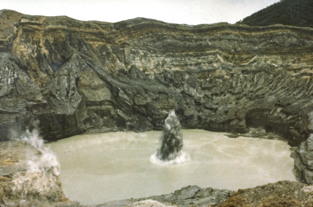 A plume containing ash and mud erupts through the Poás crater lake in July 1977 when phreatic explosions were produced at 25-minute intervals. This activity had begun in May 1977.  Photo by S. Racchini, 1977 (Universidad Nacional Costa Rica, courtesy of Jorge Barquero).
