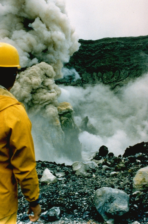 A geologist observes an ash plume rising 400 m above the summit crater of Poás on 25 April 1989. By 19 April, four days before this explosion, the crater lake had disappeared. In May 1989 ash plumes reached 1.5-2 km above the crater.  Photo by Gerardo Soto, 1989 (Instituto Costarricense de Electridad).