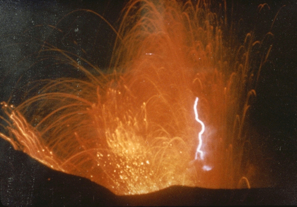 This photo captures volcanic lightning within incandescent ejecta from the Irazú summit crater in 1963. Intermittent ejection of ash, lapilli, blocks, and bombs took place for two years beginning from March 1963. Late in 1963 an ash plume reached 8 km above the vent in four minutes.  Photo by M. Esquivel, 1963 (published in Barquero, 1998).