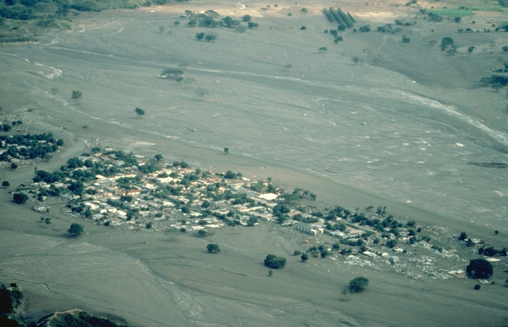 The 1985 eruption of Colombia's Nevado del Ruiz volcano produced the deadliest lahars (volcanic mudflows) in recorded history.  A relatively moderate explosive eruption melted parts of the summit icecap and sent lahars down four major drainages.  The town of Armero, shown here, was destroyed by a lahar that had traveled 74 km east of the summit and exited a narrow canyon above the town in a 40-m-high wave.  Three-quarters of the 28,000 inhabitants of Armero were killed because officials and residents were not prepared for the danger the volcano posed. Copyrighted photo by Katia and Maurice Krafft, 1985.