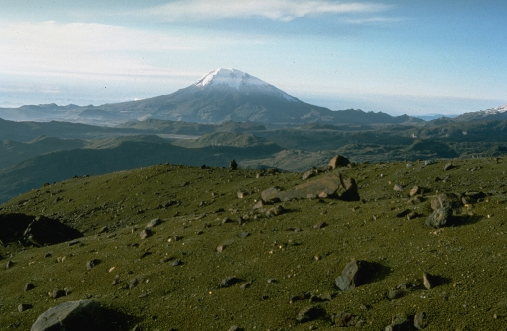 Glaciated Tolima volcano is seen here looking south from the flank of Nevado del Ruiz. The summit consists of late-Pleistocene to Holocene lava domes and contains a crater 200-300 m deep. Holocene activity has ranged from moderate explosions to Plinian eruptions. A recent major eruption took place about 3,600 years ago and minor explosive eruptions took place in the 19th and 20th centuries. Photo by Tom Pierson, 1985 (U.S. Geological Survey).