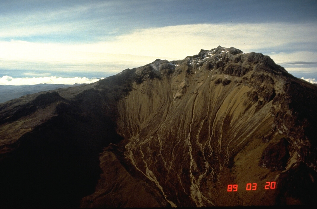 Cumbal is the southernmost historically active volcano of Colombia.  It is seen here from the north, with a young lava dome occupying the 150-m-wide summit crater.  Flank craters, the youngest of which is Boca de Mundo Nuevo, have formed along radial fissures on the east and south flanks of the nearly symmetrical volcano.  Eruptions from the upper east flank produced a 6-km-long lava field.  Explosive eruptions in 1877 and 1926 are the only known historical activity from Cumbal.     Photo by Norm Banks, 1989 (U.S. Geological Survey).
