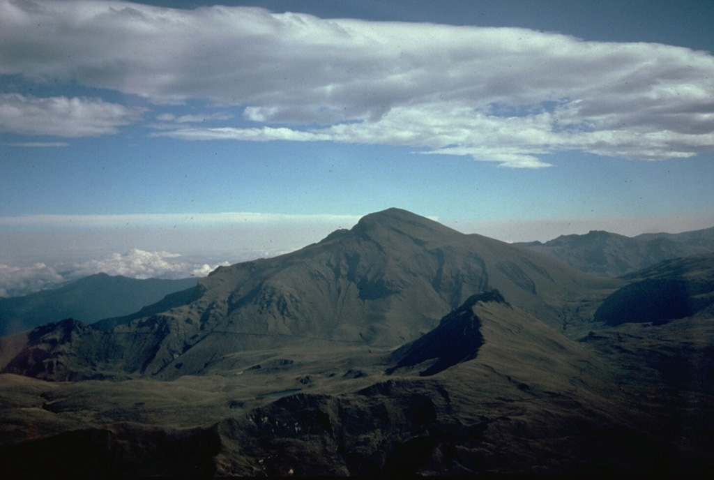 Cerro Negro de Mayasquer is the youngest of a pair of twin volcanoes along the Ecuador-Colombia border.  It is seen here from the Ecuadorian side  on the south.  The long ridge to the left of its summit is the rim of a horseshoe-shaped caldera that is breached to the NW. Photo by Minard Hall, 1985 (Escuela Politécnica Nacional, Quito)