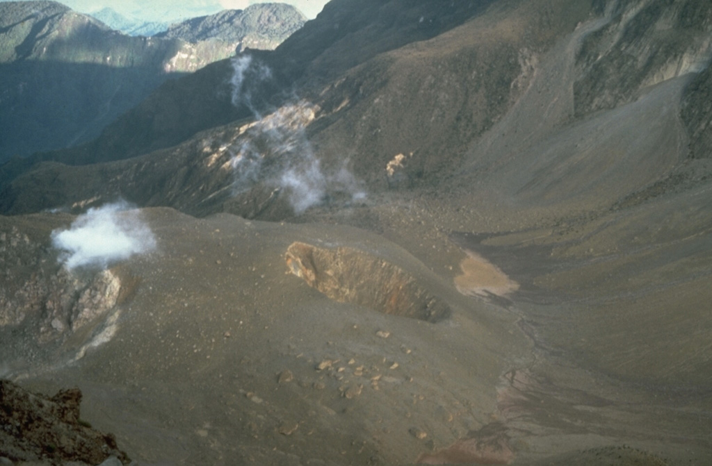 The small crater in the center of the photo was formed during phreatic eruptions in 1981-82 that blasted a hole on the NE side of the lava dome filling the summit caldera of Guagua Pichincha volcano.  The first explosions in late August or early September 1981 were followed by others that by May 1982 had merged three small craters into a larger 50-m wide crater.  A month later the crater had grown to the 100-m-wide size seen in this 1988 photo.  The eruption lasted until late 1982. Photo by Norm Banks, 1988 (U.S. Geological Survey).
